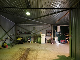 пылесос, холодильник, печь, нагревательный бак, стулья и прочие предметы обихода в гараже оригинальной загородной дачи для съемок кино