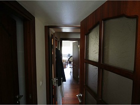 деревянная дверь гостиной  с рифленным стеклом в трехкомнатной квартире педагога
