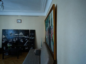 большая модульная картина и картина с изображением Гагарина и Терешковой над диваном в гостиной стильной квартиры художника