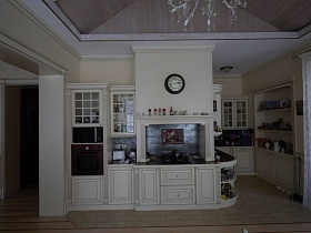 круглые черные часы на стене над плитой в кухне
