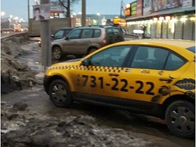 такси и легковые машины припаркованные на расчищенной от грязного снега площадке напротив блинной фастфуд закусочной