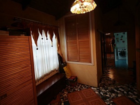 оригинальные короткие шторы на окне с белой гардиной над деревянным ящиком в коридоре с мозаичной люстрой современной семейной дачи