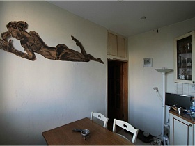 фигура девушки на белой стене кухни простой сталинской квартиры 90 годов