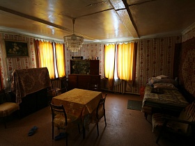 сервант с посудой в углу между окнами и накрытый тканью телевизор в гостиной дачи СССР