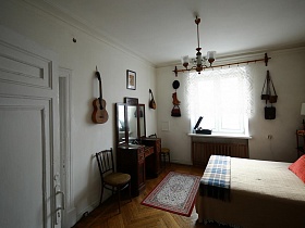 музыкальные инструменты на стене в спальне сталинки эпохи СССР