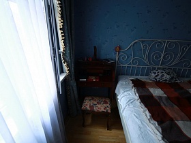 гримерный столик с пуфиком у окна в голубой спальне трехкомнатной актерской квартиры