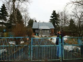 старая голубая краска на воротах с металлическими прутьями на входе во двор деревянной избы в деревне