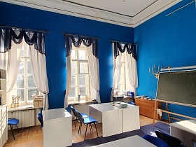 Класс школы с синими стенам и белой мебелью для съемок