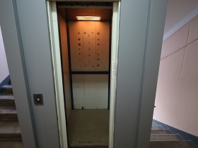 открытые двери лифтовой кабины на этаже подъезда жилого многоэтажного дома