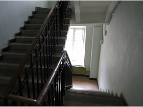 бетонные ступени с перилами лестничной клетки с белыми стенами в жилом доме