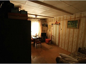 картина на стене и иконы в углу комнаты с полосатыми обоями на зеленой даче