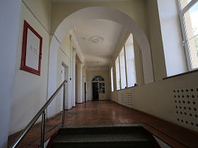 бетонные ступени под мрамор с металлическими перилами в светлый коридор Дома Культуры советского времени с арочным дверным проемом , белым потолком и большими окнами
