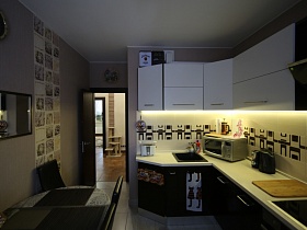 коричневый низ, белый верх мебельной стенки с тостером, микроволновкой и электрочайником на бежевой столешнице светлой кухни модной современной квартиры