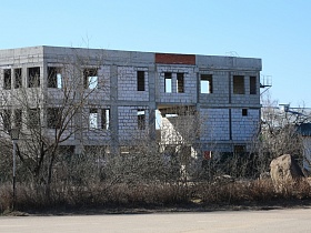 строящийся блочный светлый дом без крыши и стекол в черте провинциального городка Сычево