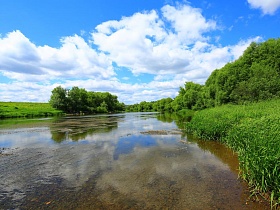 отражение белых облаков в воде на мелководье извилистого устья реки в живописном месте-холмогоры
