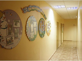 красочный стенд на стене с фотографиями детей и событиями в детском саду