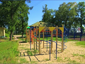 детская площадка с ярким спортивным снаряжением на территории сельской школы