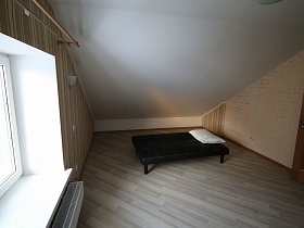 аскетическая комната на мансарде кирпичного двухэтажного дома