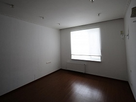 ролеты на окне большой светлой пустой комнаты