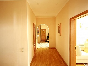 светлые стены коридора с коричневым линолеумом на полу и арочным дверным проемом в прихожую простой семейной четырехкомнатной квартиры в Марьино
