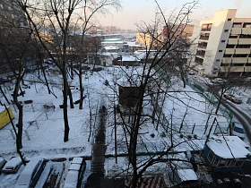 вид на дорогу, соседние дома, гаражи и придомовую территорию под снегом из окна трехкомнатной квартиры СССР