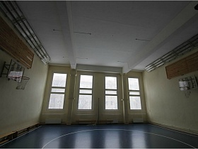 баскетбольные сетки на стенах и деревянные скамейки в отдельной сортивной комнате школы