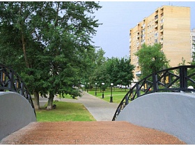 мостик с кованными перилами в парке фонтанов в жилом квартале