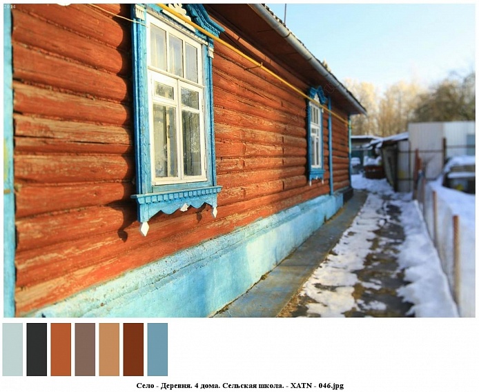 стены деревянного дома на высоком цоколе окрашены в коричневый цвет, с мелкими стеклами в белой раме окна с голубыми наличниками
