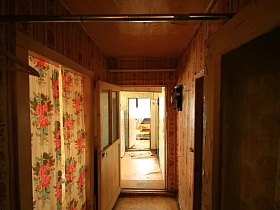яркая штора с красными розами в дверном проеме прихожей комнаты с турником и электро счетчиком на стене