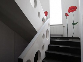 красные маки на белой стене лестничной площадки креативного дома