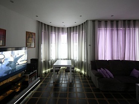 высокие окна прозрачными гардинами в гостиной дома Диджея