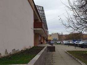 общий вид длинного двухэтажного здания столовой с открытыми балконами под белой пластиковой крышей