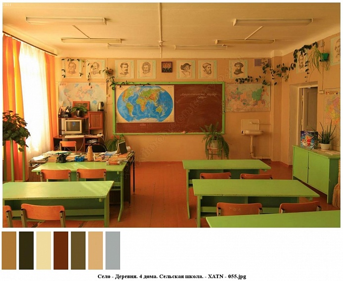 портреты выдающихся ученных, географические карты на светлых стенах чистого, ухоженного школьного класса с зелеными партами и учительским столом