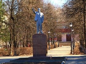 черные фонарные столбы вдоль широкой дорожки, ведущей к центральной площади с памятником Ленина на постаменте в Сычево