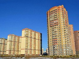 ряды современных высотных жилых двухцветных домов в бежево-коричневом цвете новостройки