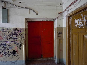 яркие красные входные двери в коммунальном общежитии