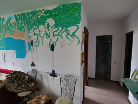 изображение природы на разрисованной стене гостиной простой трехкомнатной квартиры