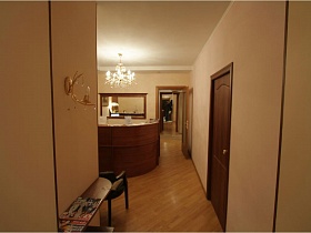 люстра на белом потолке в комнате с ресепшн съемной трехкомнатной современной квартиры