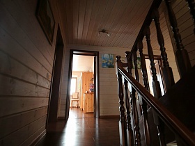 картина на стене просторного холла у входной двери в спальную комнату деревянного трехэтажного дома