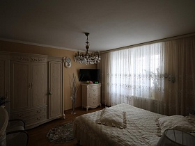 общий вид спальной комнаты с белой мебелью в большой квартире врача