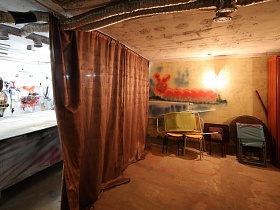 коричневая штора делит мастерскую на две комнаты