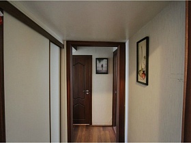 картина на стене светлого коридора со встроенным шкафом-купе в квартире педагога
