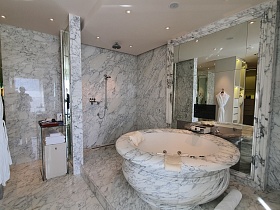 Круглая ванна из мрамора в номере отеля