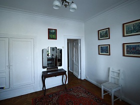 белый стул у стены  под картинами