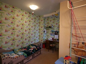 детская деревянная кровать с ярким покрывалом и детский комод у стены детской в современной трешке