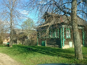 деревянный жилой дом-сруб на два хозяина с подполом, зелеными резными наличниками в старой деревне