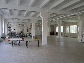 производственное оборудование химической лаборатории N 18 в белом просторном помещении с балочным потолочным перекрытием и белым кафелем на полу
