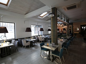 сервированные столики на два-четыре человека на деревянном полу уютного ресторана в светлом стиле на берегу озера