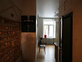 декоративное пано и картина на стене прихожей у входа на кухню с белыми стенами современной двухкомнатной лофт квартиры