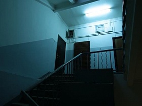 входные двери жилых квартир на этажах серого подъезда 12 с винтовой лестницей жилого дома времен СССР
